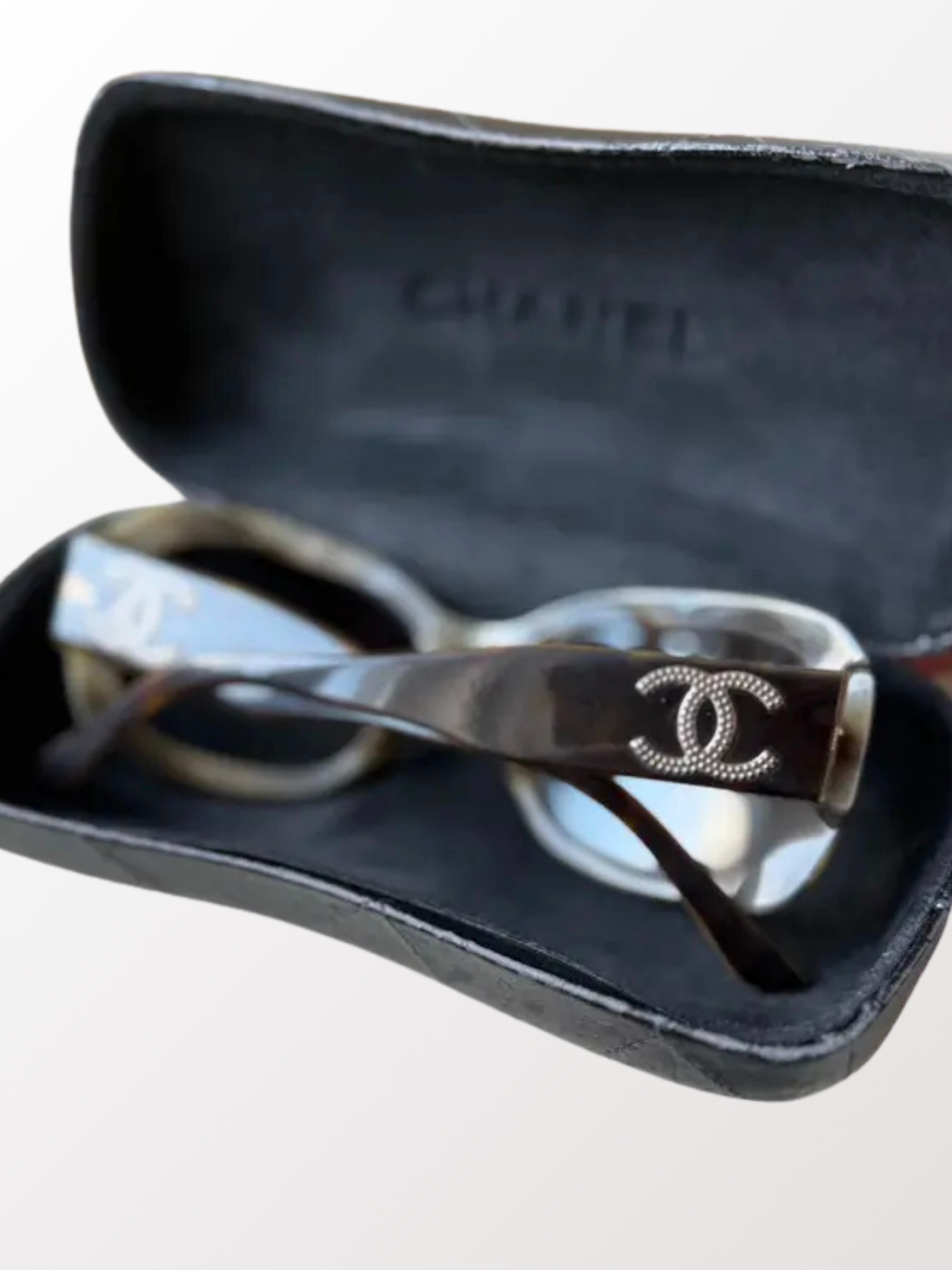 Close-up of silver CC logo on temple of Chanel vintage sunglasses